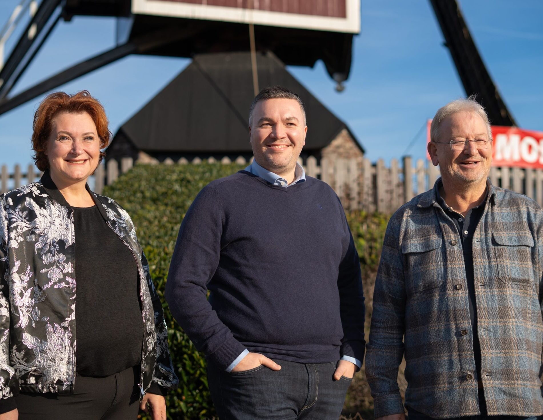 Mariëlle Verdouw-de Vet (l), Daan Jansen (m) en Erik Kuenen (r) poseren lachend bij de molen in Mierlo.