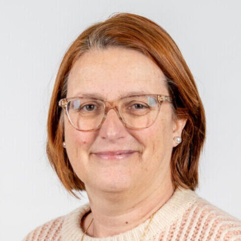 Vrouw met rossig, schouderlang haar en bril glimlacht vriendelijk. Foto is gemaakt in Geldrop-Mierlo.